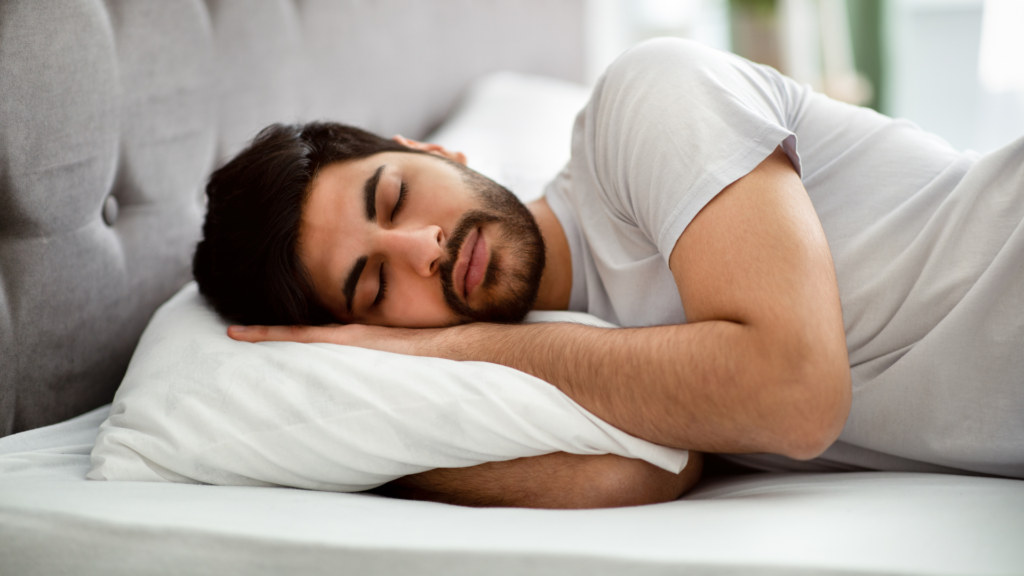 Man sleeping in bed illustrating the topic of nocturnal emissions and male reproductive health balance